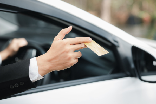 asian-man-formal-suit-stays-car-opens-window-handed-his-credit-card-pay-gas-travel-by-car-safe-driving-respecting-traffic-rules